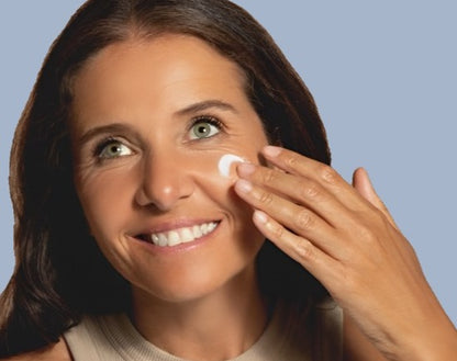 A healthy athletic woman rubs Fast Legs Moisturiser with SPF15 into her face.